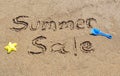 Summer sale written in the sand